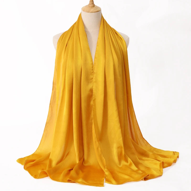 Helles gelbes Satin-Crinkle-Hijab-Schal, um den Hals eines Mannequins gewickelt.