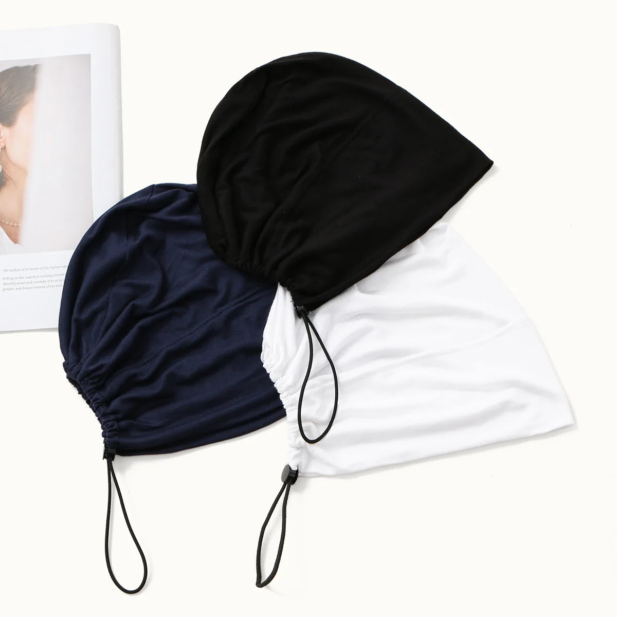 Black and navy adjustable modal hijab caps displayed together on a white background