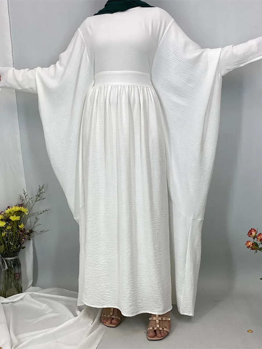 Elegante weiße Batwing-Abaya für Damen auf einem Bügel.