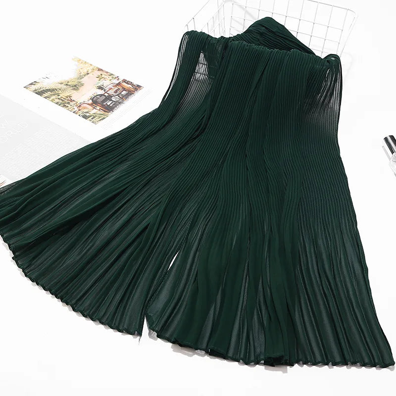 Dunkelgrüner Crinkle-Chiffon-Hijabschal, drapiert auf weißer Fläche.
