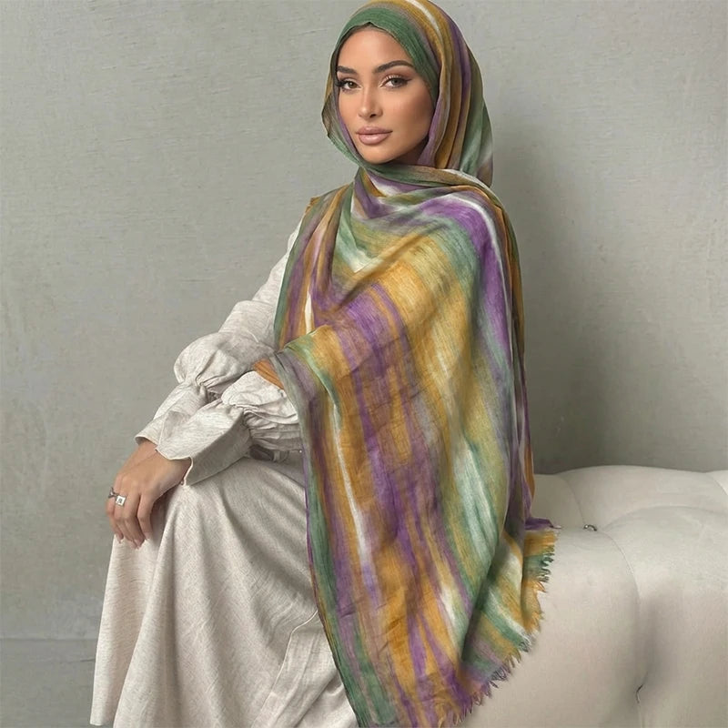 Una mujer usando un pañuelo de hijab floral de acuarela bohemio y colorido sobre su hombro.