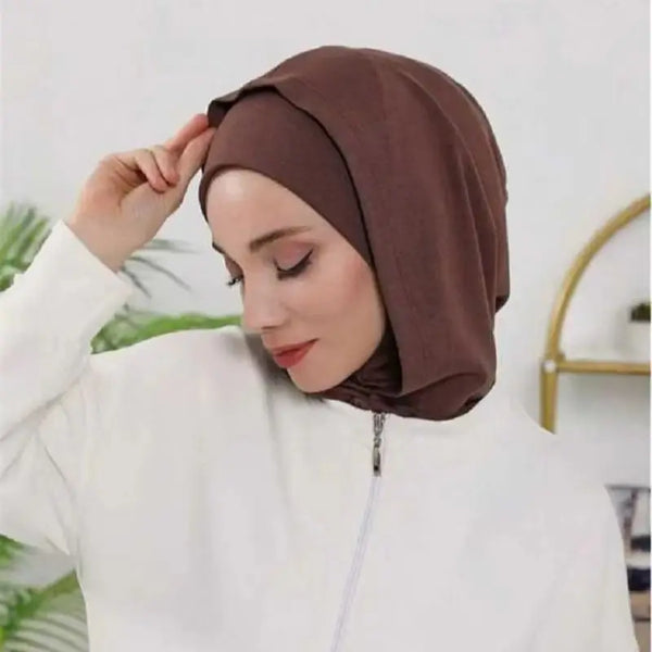 A woman wearing a brown instant double layer hijab cap and a white top.