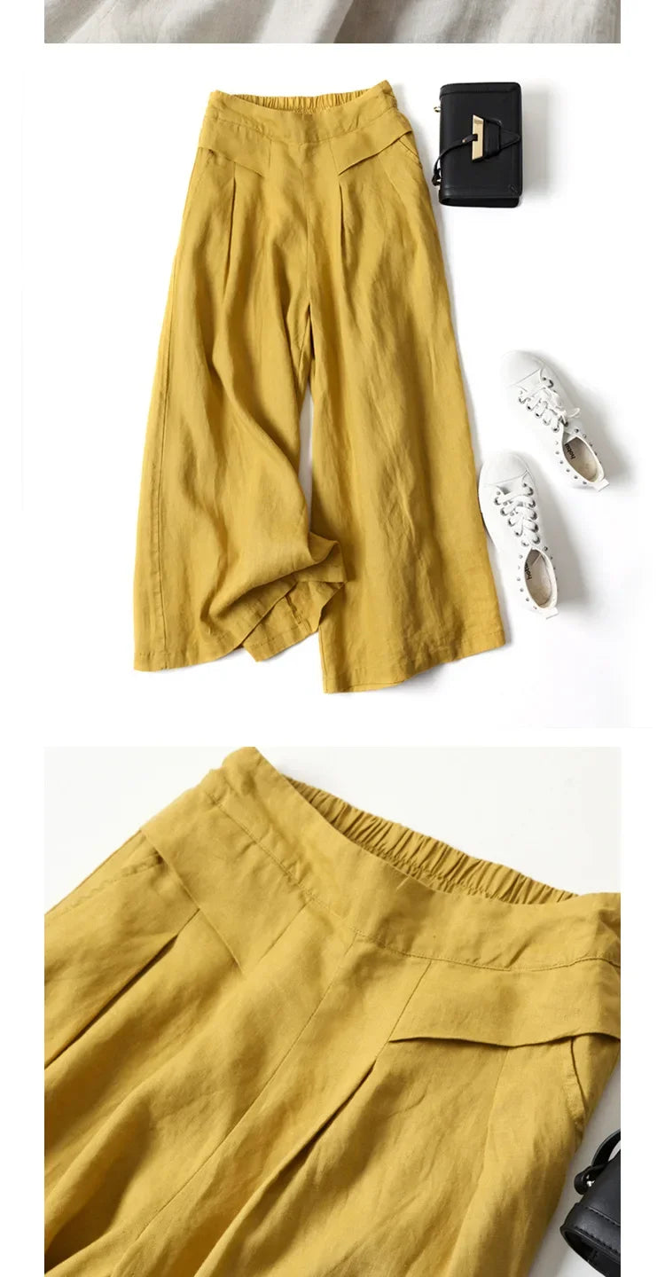 Senffarbener Leinen-Mix-Palazzo-Hose mit weiter Bein, neben einer schwarzen Geldbörse und weißen Schuhen.