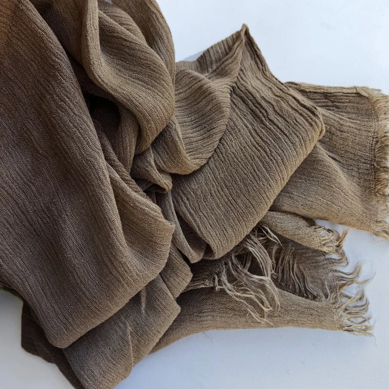 Une pile de foulards de hijab en coton viscose vert olive avec pompons