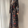 Manteau trench femme à longue portée avec motif floral sombre et accents rouges, présenté sur mannequin.