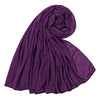 Ein tiefviolettes Baumwoll-Jersey-Hijab-Tuch, gerollt und drapiert, zeigt seine weiche Textur.
