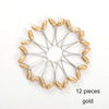 A circular arrangement of twelve gold pearl brooch headscarf pins.