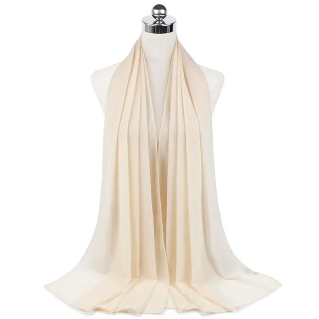 A beige chiffon hijab scarf draped around a mannequin neck.