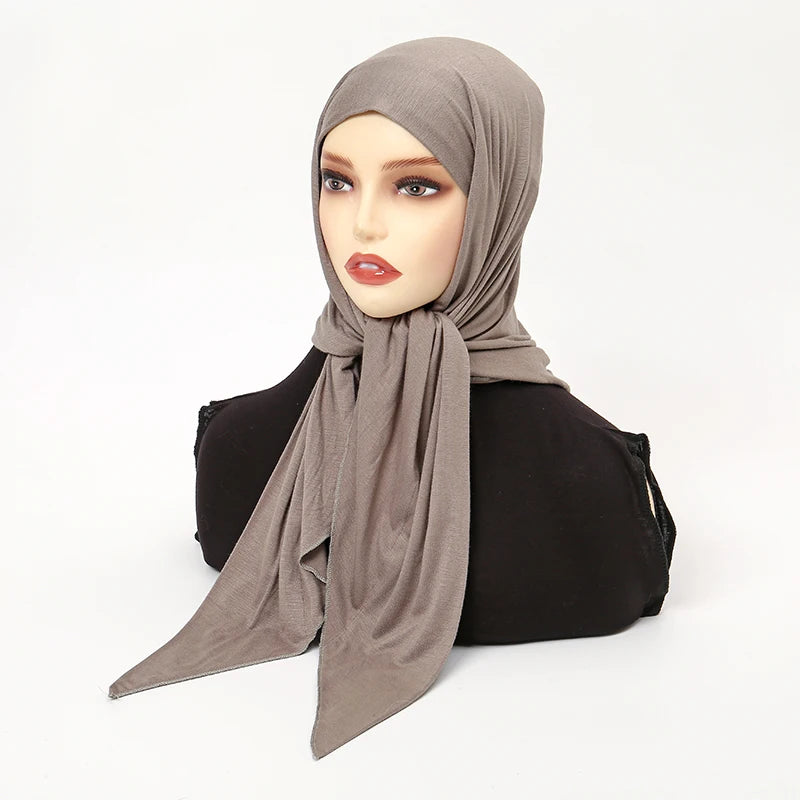 Un mannequin portant un foulard triangle uni taupe avec un haut noir.