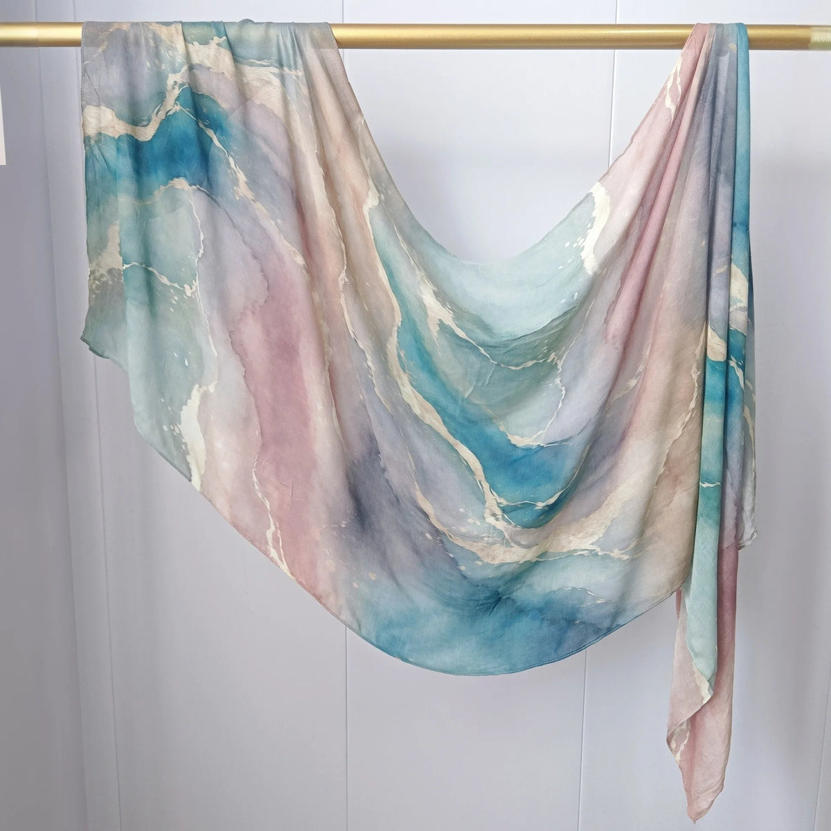 Fließender, mehrfarbiger Kopftuch mit marmorierten Tönen in Rosa, Blau und Creme.
