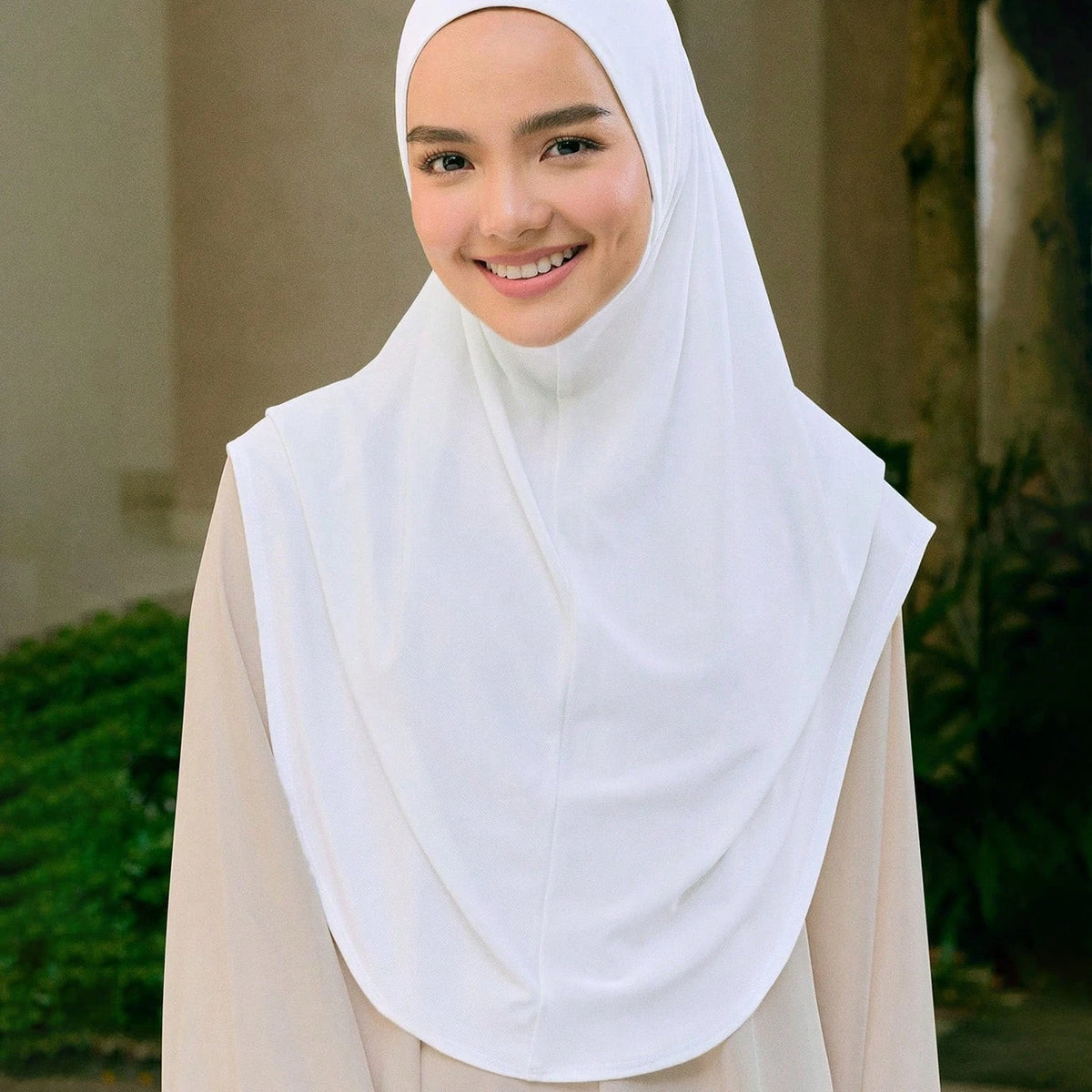 Une femme portant un foulard turban en tissu coton chanvre blanc et une tenue extérieure beige.
