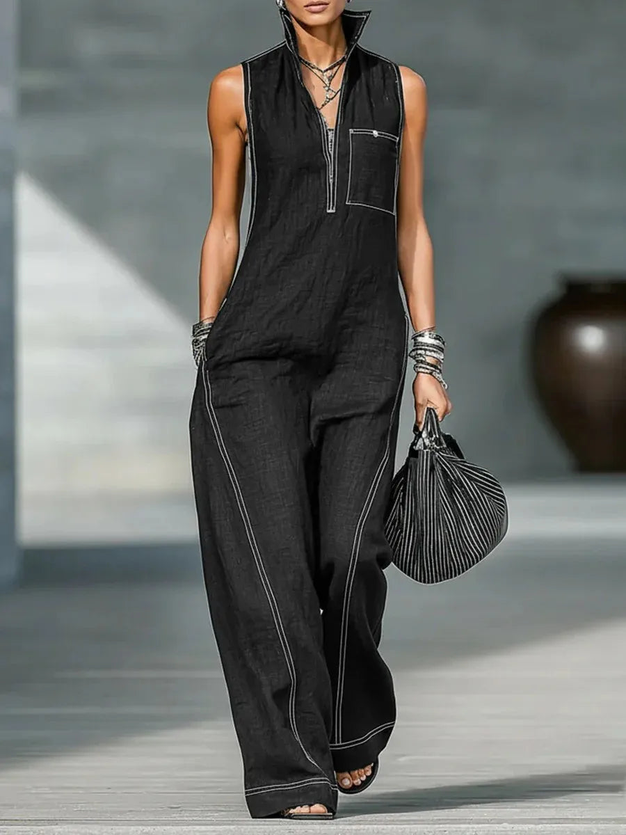 Una modelo vistiendo un top de punto negro sin mangas y pantalones a juego con joyas plateadas.