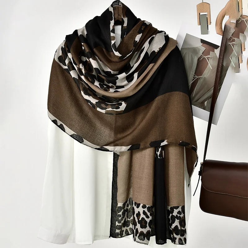 Écharpe viscose imprimé léopard marron et noir drapée sur un vêtement blanc.
