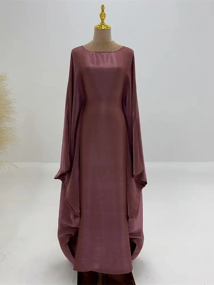 Una abaya de batwing de satén malva exhibida en un maniquí.