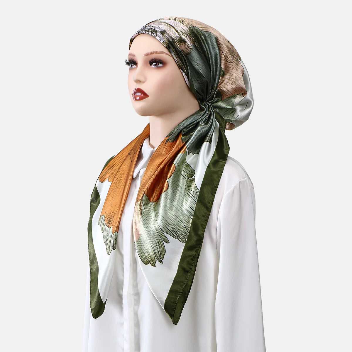 Une femme modélise un foulard instant anti-dérapant imprimé en satin dans des tons de vert olive, or et crème.