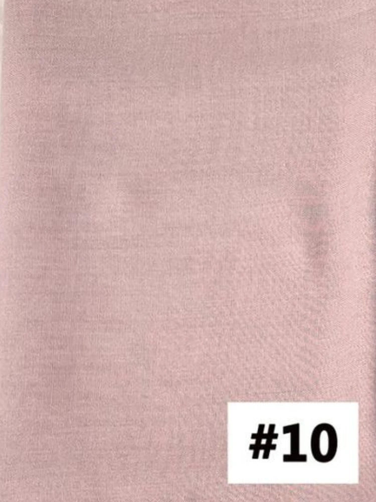 Gros plan sur un tissu de foulard modal de couleur rose poudré et doux.