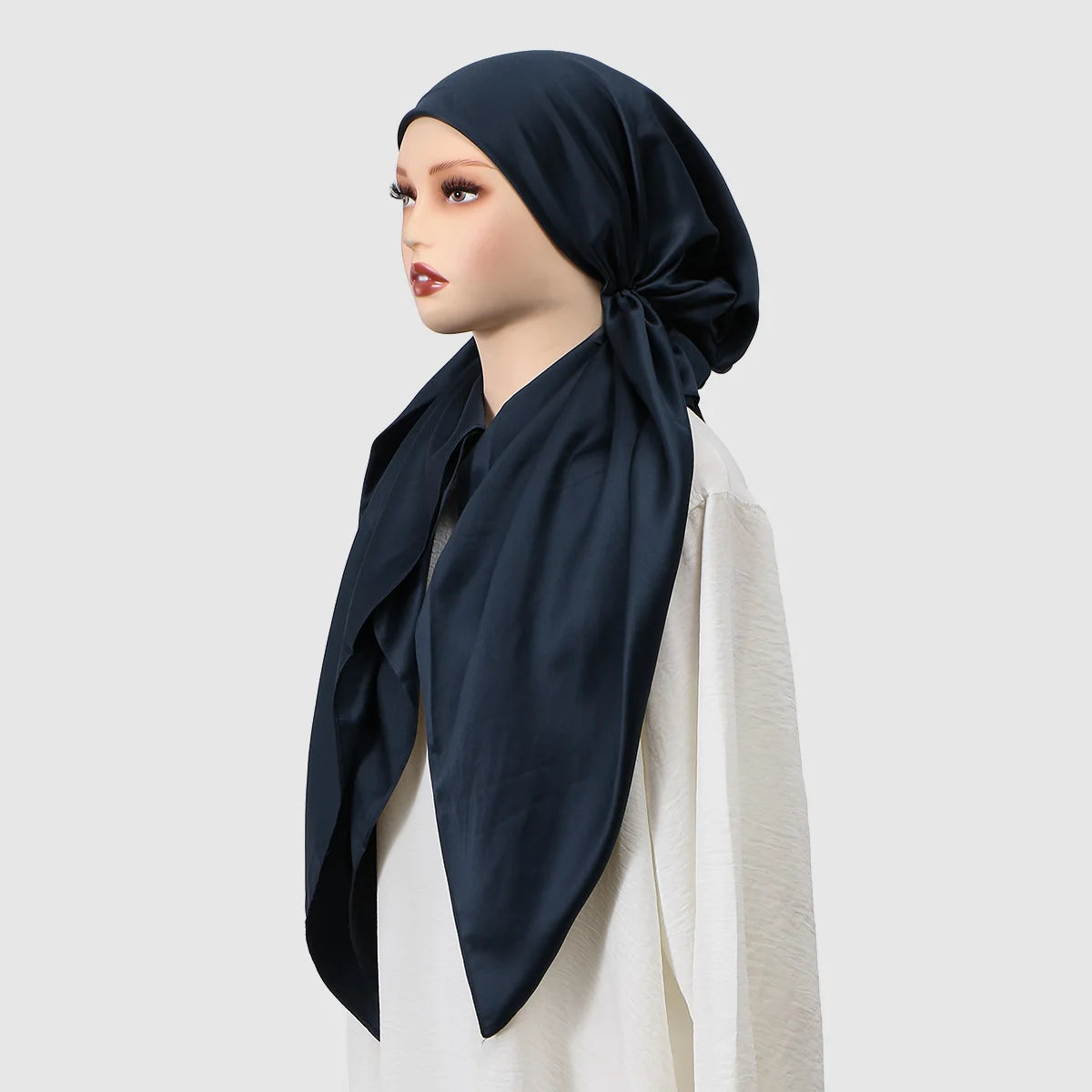 A woman models a navy blue satin silk instant hijab scarf draped around her neck and shoulders.
