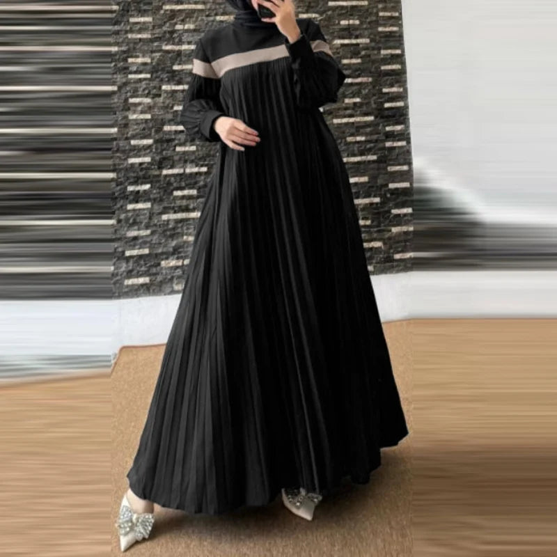 Une femme portant une longue caftan patchwork noir et fluide.