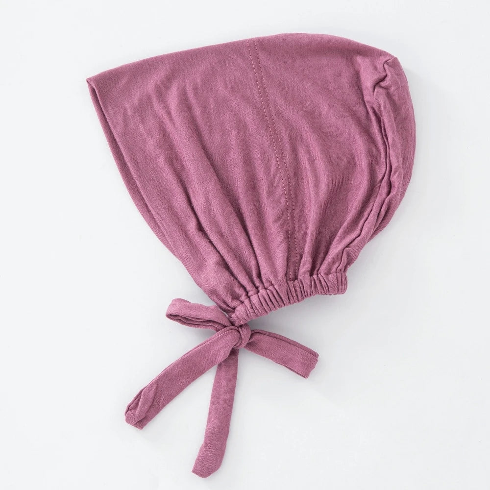 Verstaubte rosafarbene innere Hijab-Haube, gefaltet und am unteren Rand gebunden.