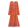 An orange floral lantern sleeve maxi dress with intricate embroidery and a tiered skirt.