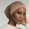 Primer plano de una mujer usando un gorro hijab de modal de algodón suave y elástico beige.