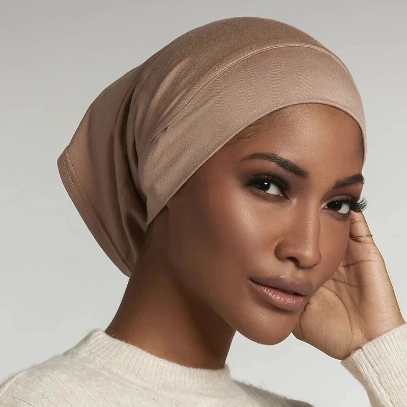 Primer plano de una mujer usando un gorro hijab de modal de algodón suave y elástico beige.