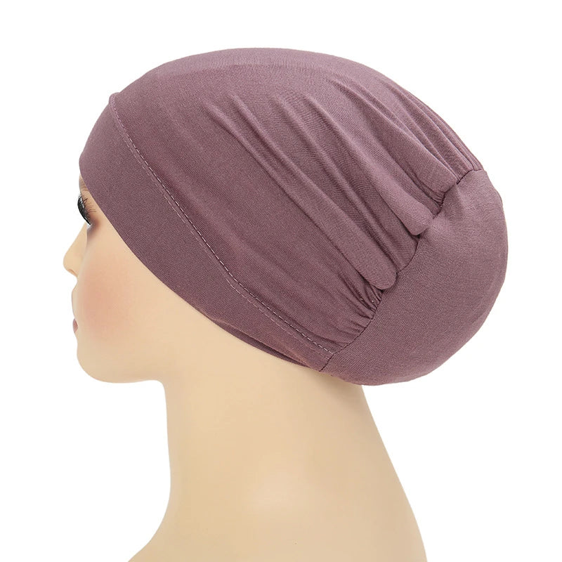 Un turbante instantáneo color malva mostrado en un maniquí de cabeza.