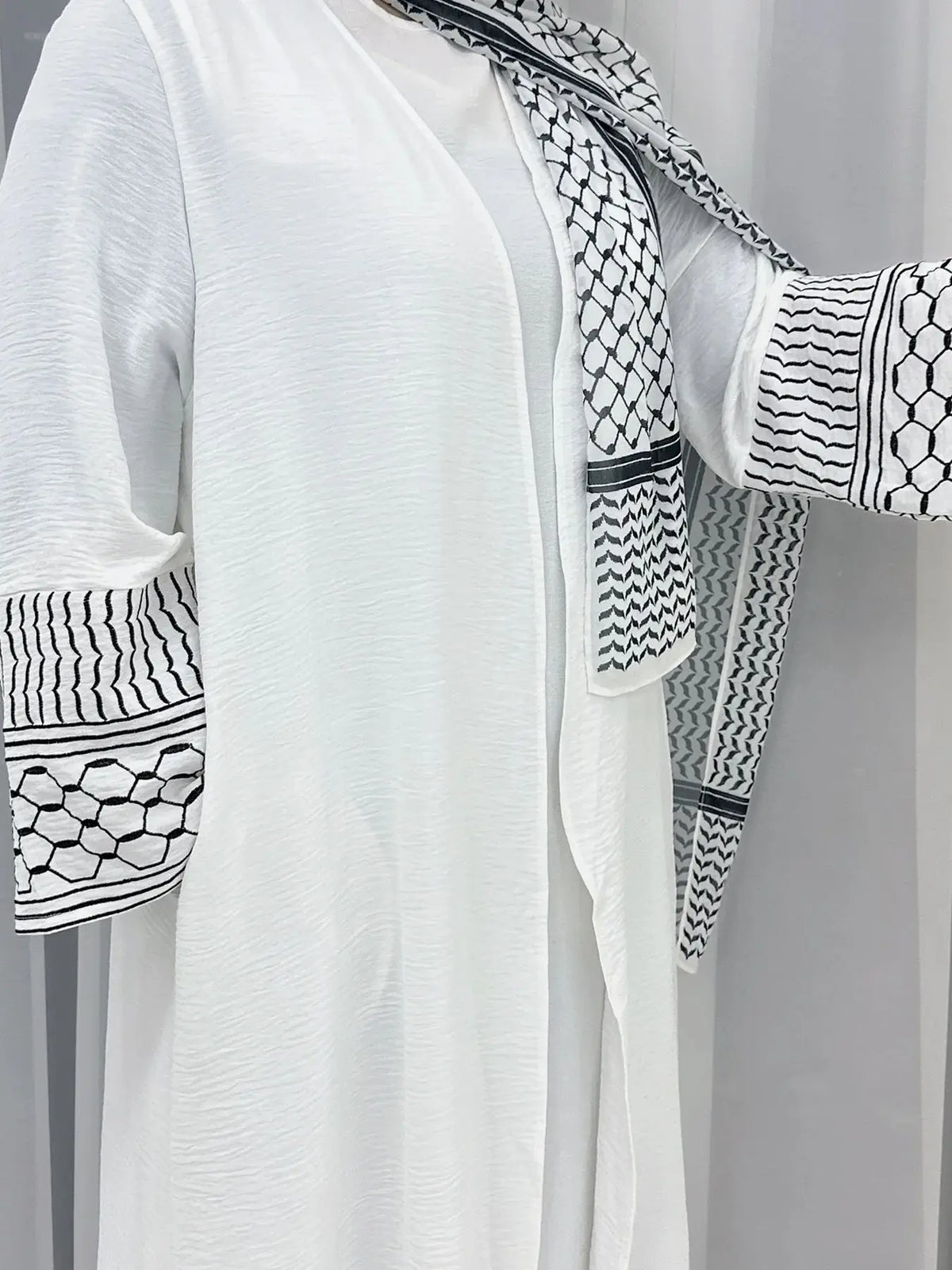 Abaya blanche élégante avec broderie géométrique noire sur les manches et le col