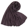 Un foulard hijab en jersey de coton violet foncé roulé et drapé, montrant sa texture douce.