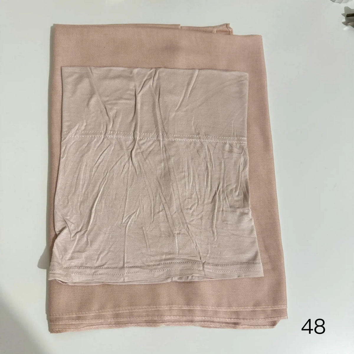 A light beige soft modal rayon hijab set for women, folded and displayed flat.