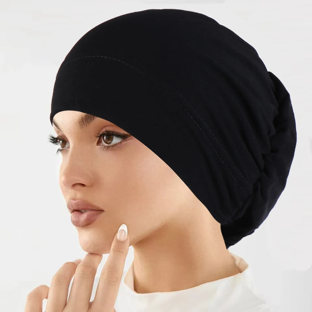 Nahaufnahme einer Frau, die eine schwarze vielseitige Stretch-Turbanmütze trägt.