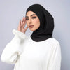 Eine Frau trägt ein schwarzes Instant-Turban-Hijab-Undercap und ein weißes Langarm-Oberteil.