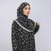 A woman wearing an elegant black and white patterned hijab dress for daily wear.