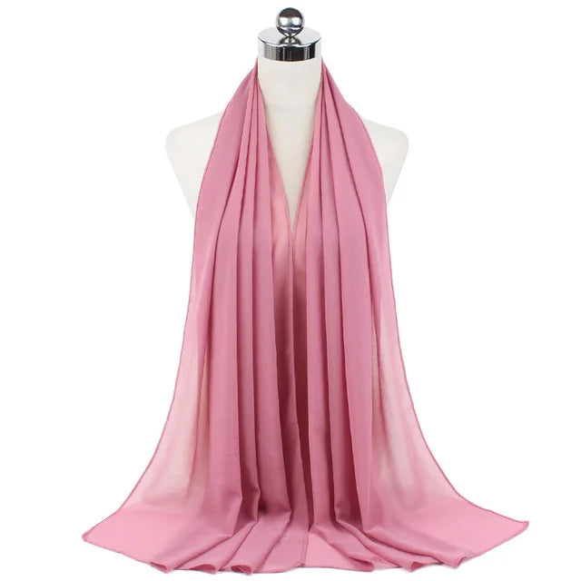 A pink chiffon hijab scarf draped around a mannequin's neck.