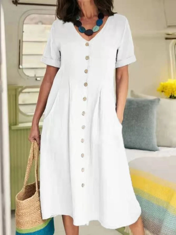 A woman models an elegant white cotton and hemp V-neck dress with short sleeves and buttons.