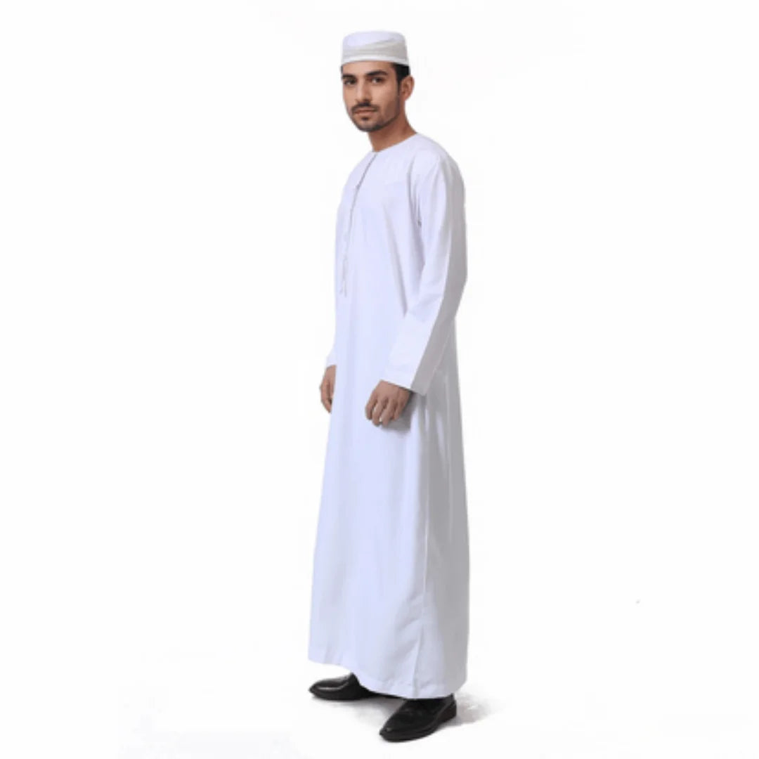 Ein Mann trägt ein weißes arabisches Langarm-Thobe und eine traditionelle Kappe.