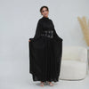 Une femme portant une élégante abaya noire musulmane avec une ceinture ornée.
