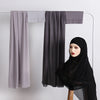 Schwarzes Hijab-Set mit durchscheinendem Stoff und solidem Chiffon, präsentiert an einem Haken.