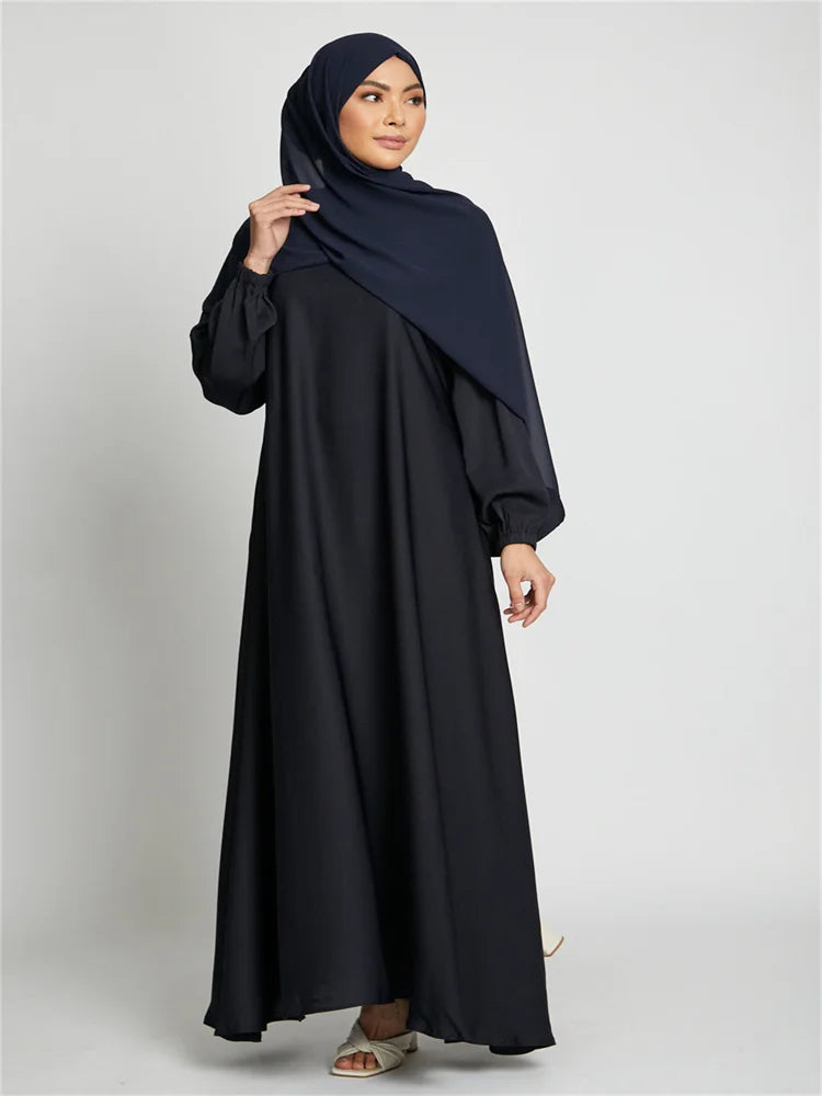 Eine Frau trägt eine dunkelblaue marokkanische Kaftan-Abaya mit passender Hijab.
