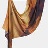 Fließender bedruckter Seideschal-Hijab in Gold-, Braun- und Dunkelorange-Tönen.