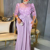 A woman models a floor-length lilac sequin African party dress with a high neckline and three-quarter sleeves.