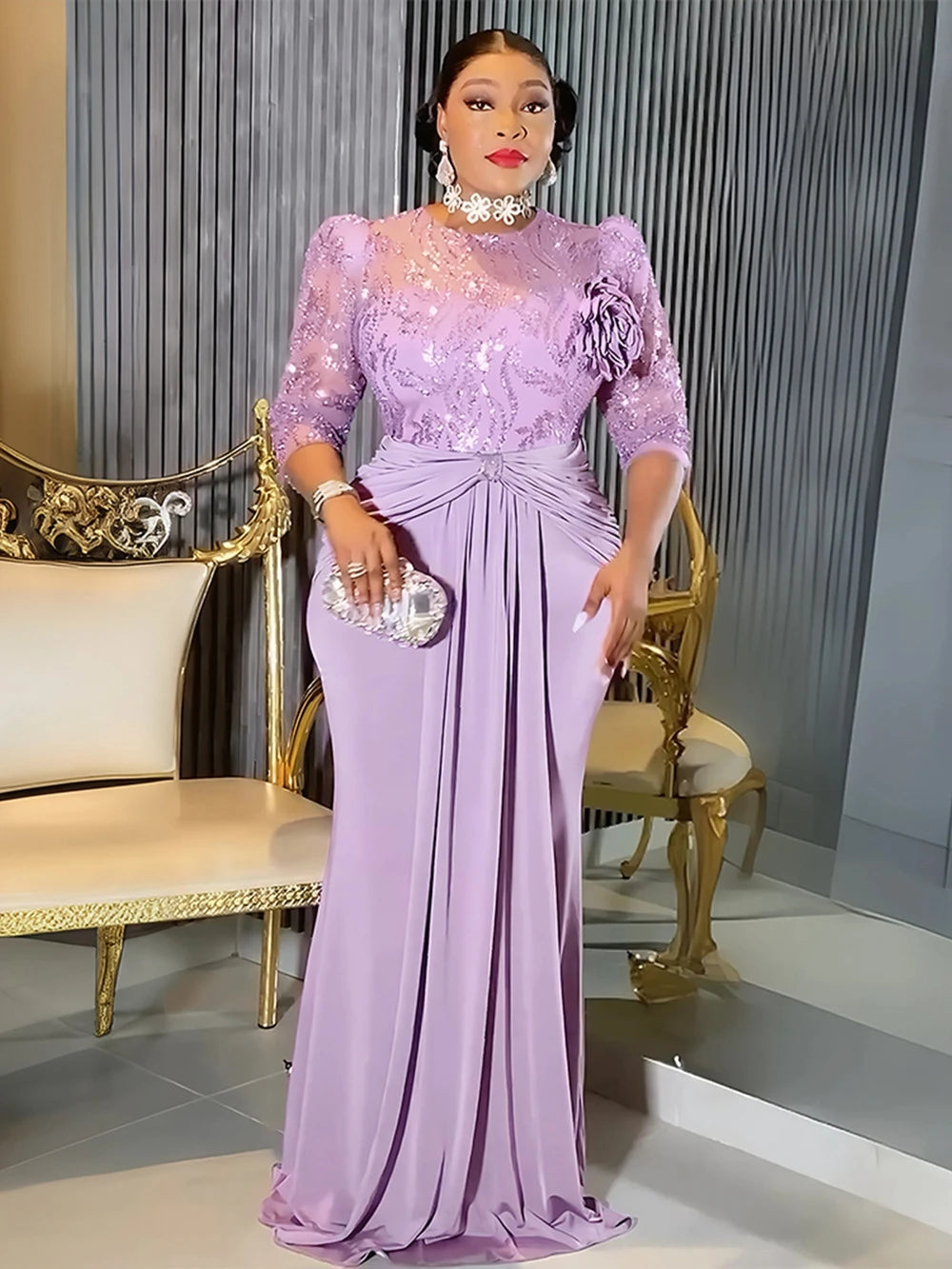 A woman models a floor-length lilac sequin African party dress with a high neckline and three-quarter sleeves.