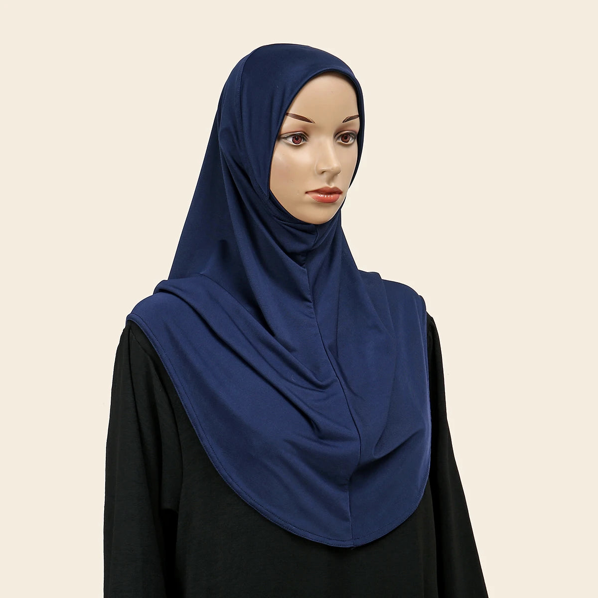 Una mujer vistiendo un pañuelo instantáneo islámico azul marino con una blusa negra.