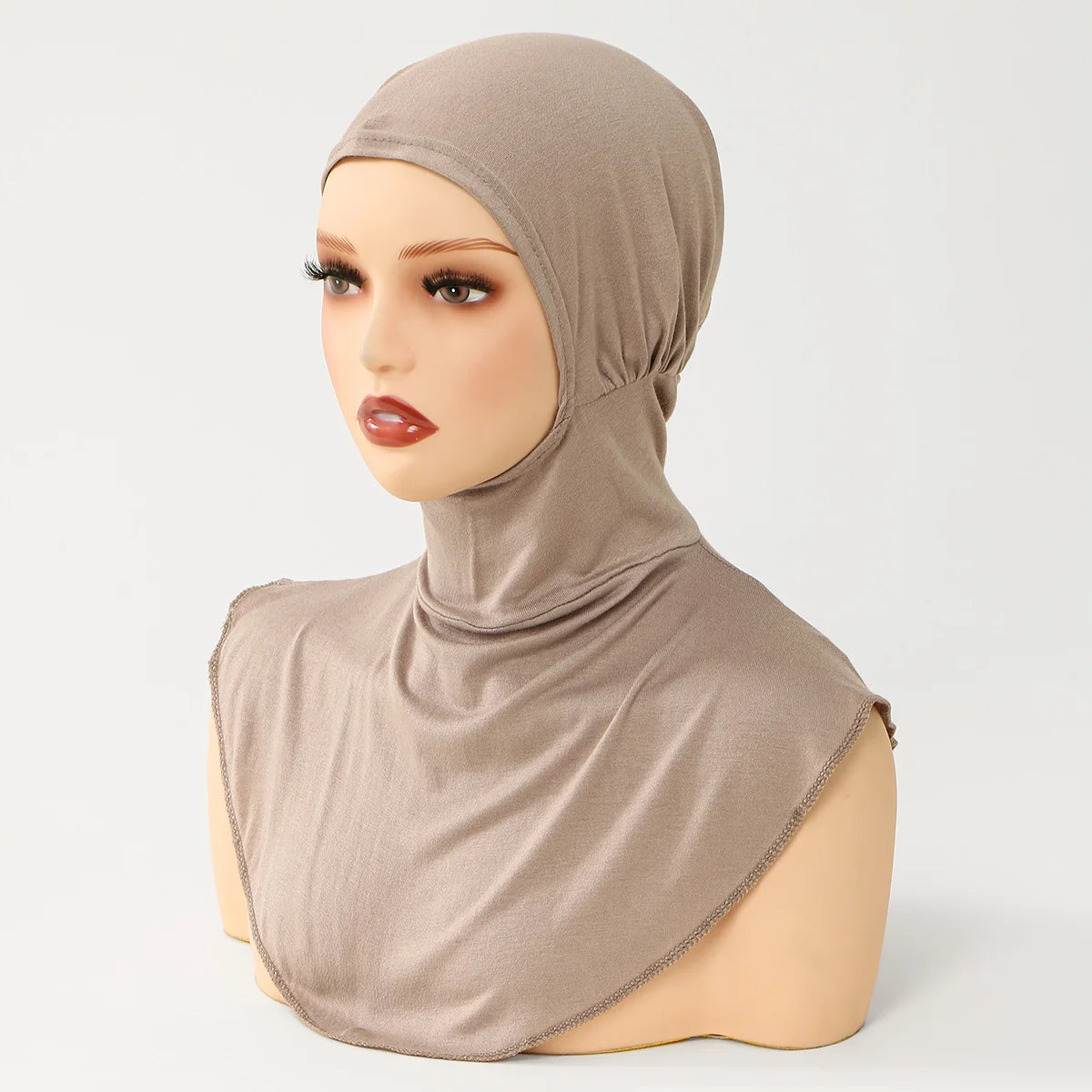Un mannequin porte un bonnet et un foulard hijab en coton mélangé beige.