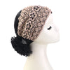 Tocado de turbante floral de cuentas y encaje beige y negro, usado en un maniquí.