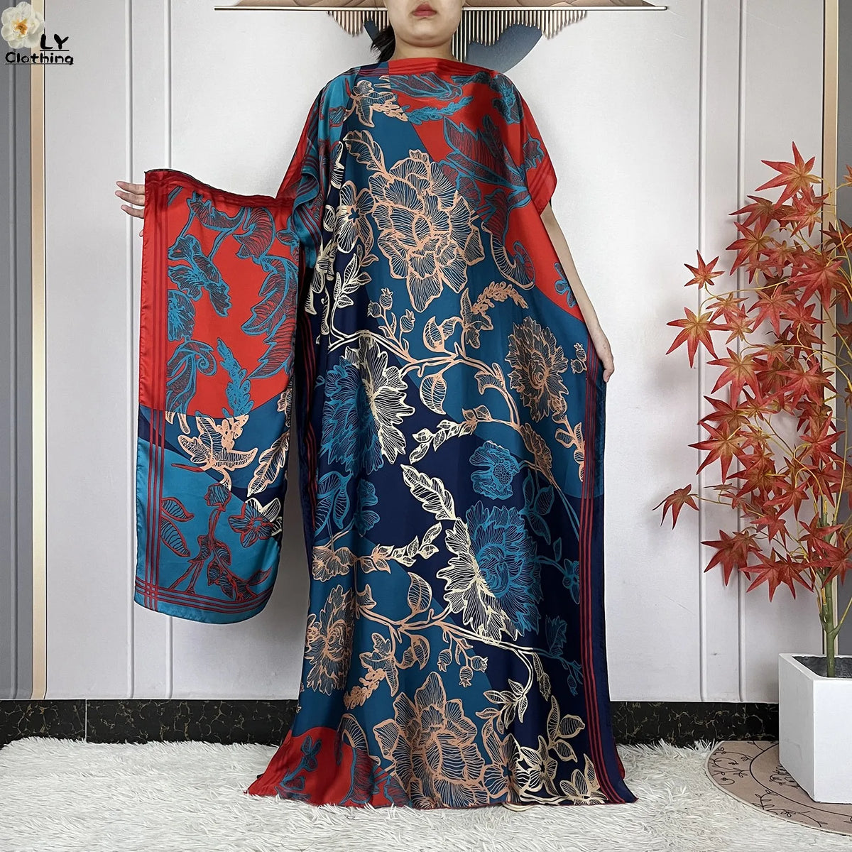Eine Frau modelliert ein blau-rotes Blumenmuster Sommer-Seidenabaya Kaftan-Kleid.
