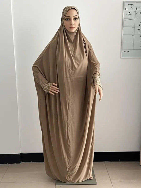Une femme portant une caftan abaya beige fluide pour la modestie.