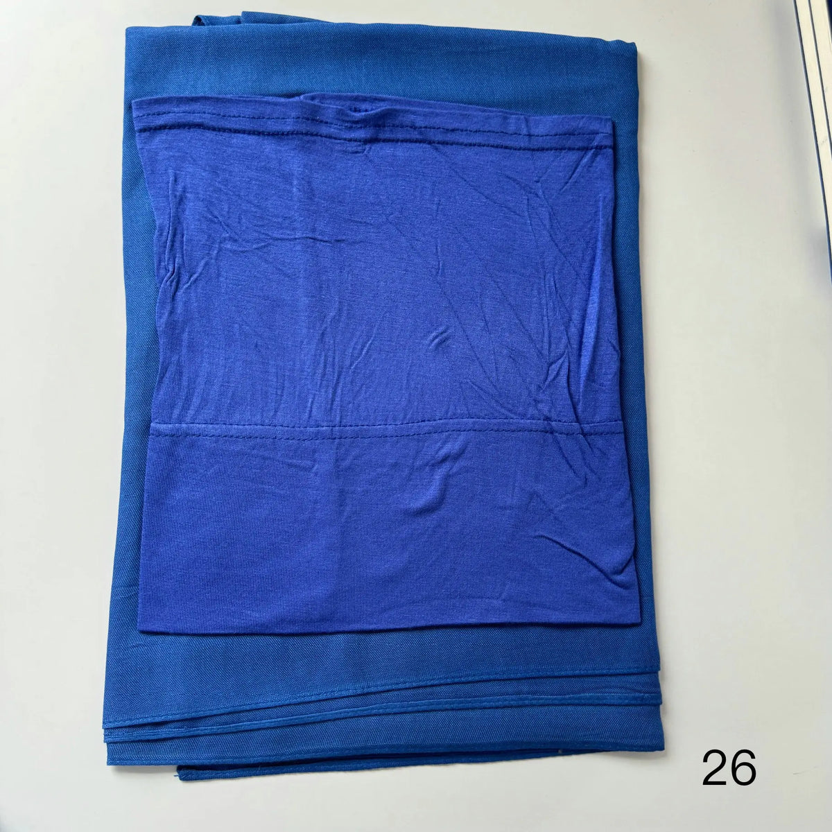 A stack of royal blue soft modal rayon hijab fabric folded neatly.