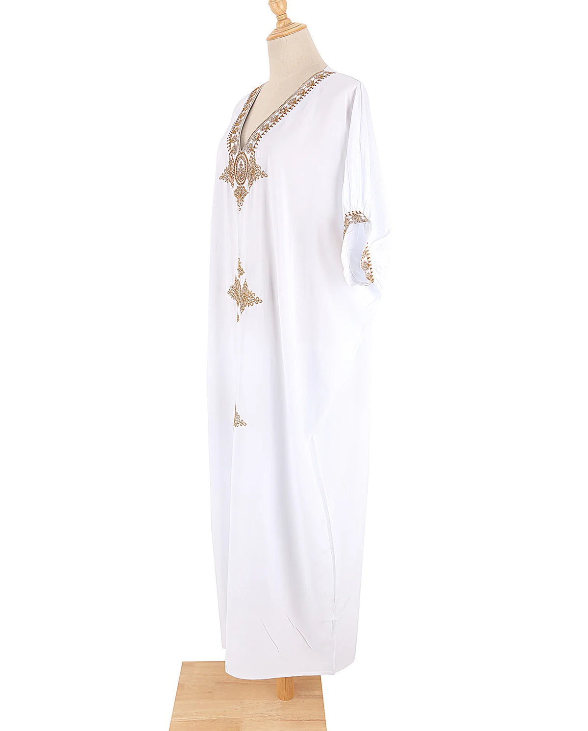 Weißer Kaftan-Kleid mit Goldstickerei und V-Ausschnitt auf einem Mannequin.