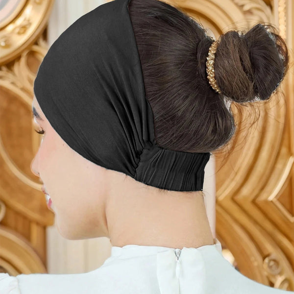 A close-up of a woman wearing a black soft cotton stretch hijab cap and headband, styled in a bun.